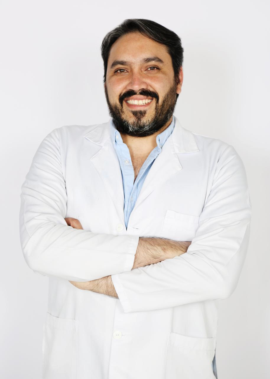 Retrato profesional del Dr. Luis Andrés Mora con bata blanca